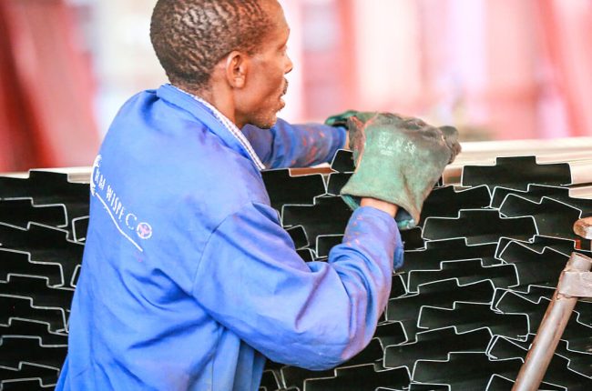 RM Wispeco employee stacking tin roofs